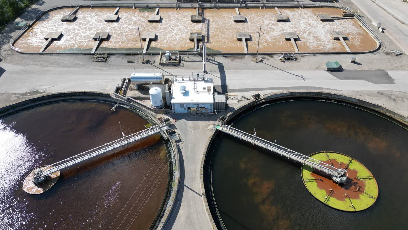Aerial view of a water treatment facility, showing circular clarifier tanks and process buildings.